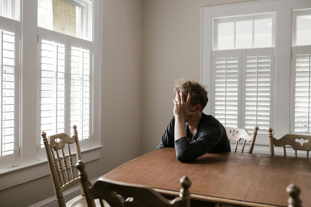 A guy sitting at his table anxious and looking out the window